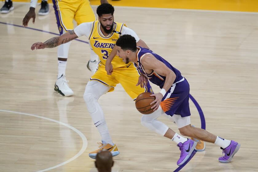 Los Angeles Lakers forward Anthony Davis (3) defends against Phoenix Suns guard Devin Booker (1) during the first quarter of Game 6 of an NBA basketball first-round playoff series Thursday, Jun 3, 2021, in Los Angeles. (AP Photo/Ashley Landis)