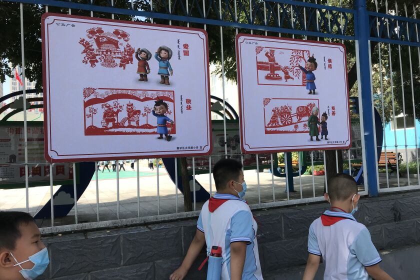 Alternate image of schoolchildren walking past patriotism signs at an elementary school in Hohhot.