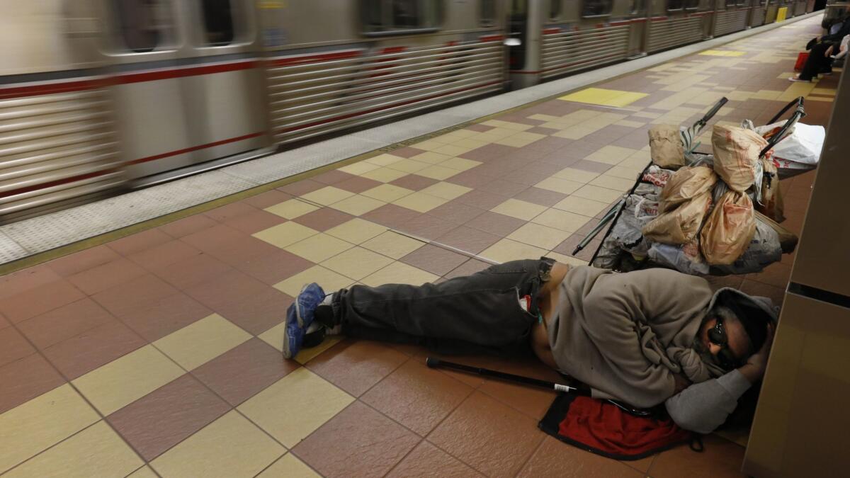 A man sleeps next to his belongings in the Hollywood/Vine Metro Red Line station.