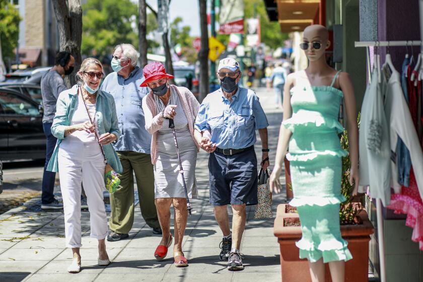 People walk along India Street in Downtown San Diego on Tuesday, July 27, 2021.(Photo by Sandy Huffaker for The San Diego Union-Tribune)