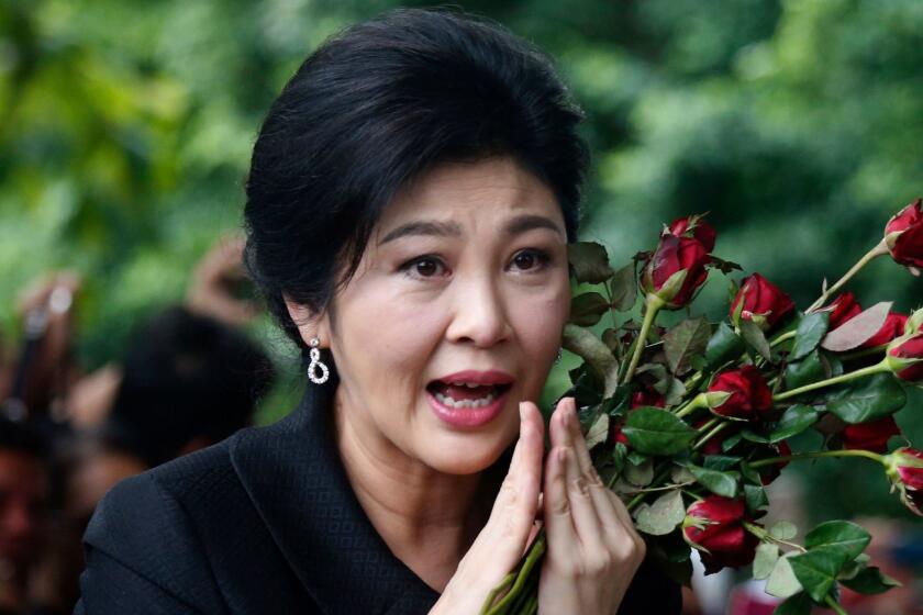In this July 21, 2017, file photo, Thailand's former Prime Minister Yingluck Shinawatra greets supporters as she arrives at the Supreme Court to make her final statements in a trial on a charge of criminal negligence in Bangkok, Thailand. A Thai court on Wednesday, Sept. 27, 2017, has sentenced former Prime Minister Yingluck Shinawatra in absentia to five years in prison for alleged negligence in a money-losing rice subsidy program. (AP Photo/Sakchai Lalit, File)