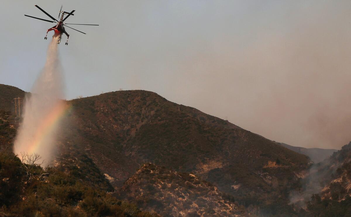 A firefighting helicopter makes a water drop on Sept. 23 during the Bobcat Fire in the Angeles National Forest.
