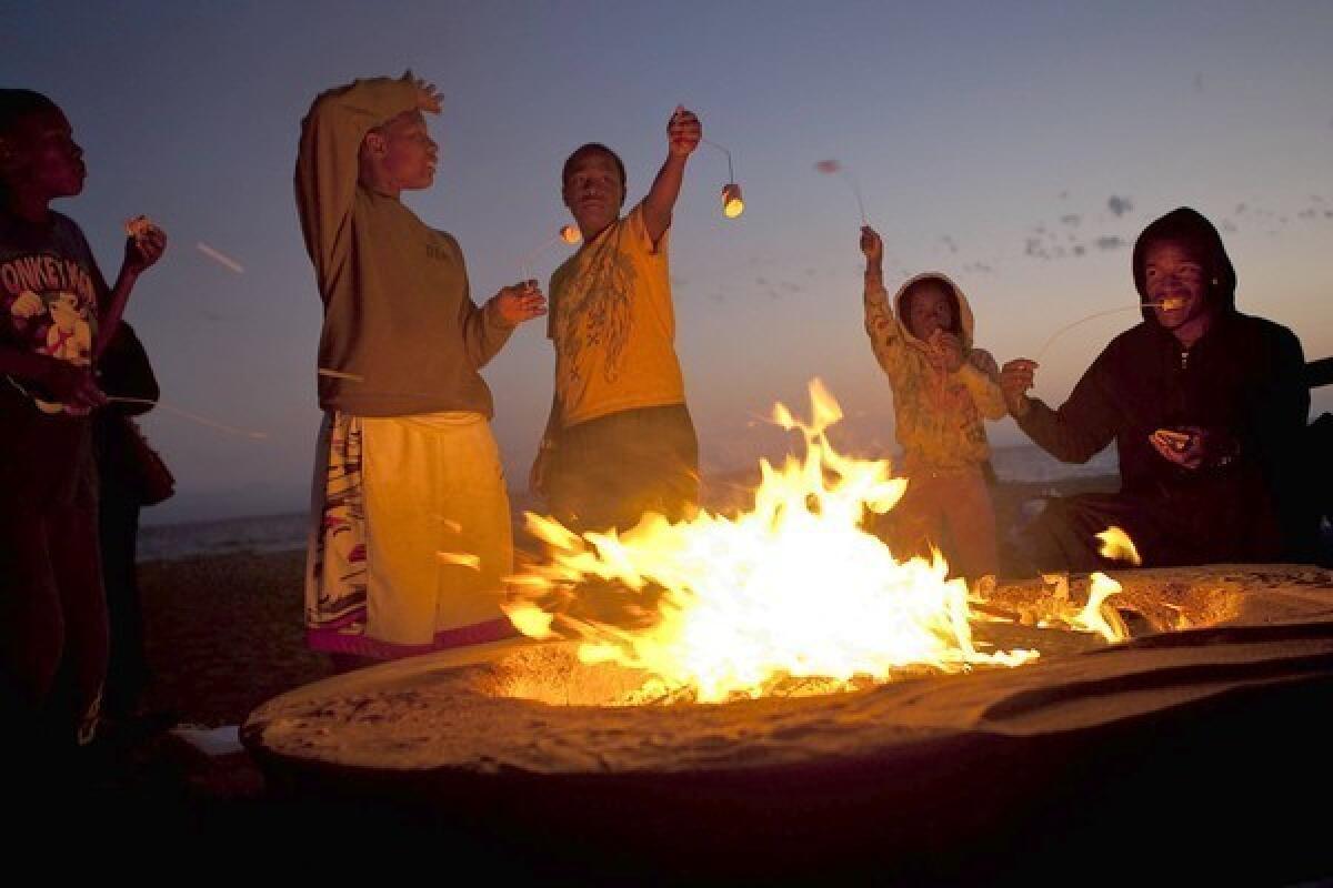 At Dockweiler State Beach last summer, beachgoers roast marshmallows at a fire ring. New air quality rules require fire rings to be at least 700 feet from homes unless the rings are at least 100 feet apart.