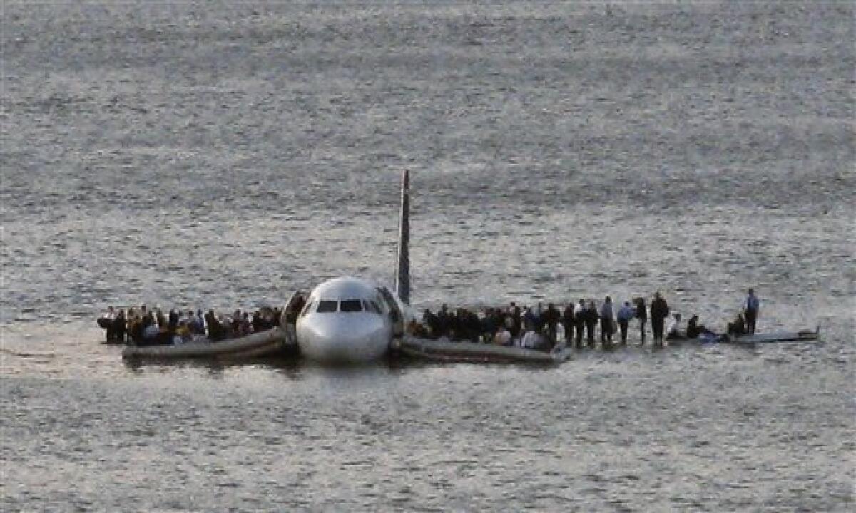 FILE - In this file photo from Jan. 15, 2009, airline passengers wait to be rescued on the wings of a US Airways Airbus 320 jetliner that safely ditched in the frigid waters of the Hudson River in New York, after a flock of birds knocked out both its engines. (AP Photo/Steven Day, File)