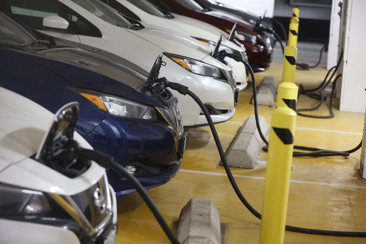 Electric vehicles charging in a parking lot.