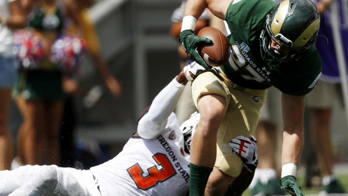 Colorado State wide receiver Trey Smith is dragged down by Oregon State safety Brandon Arnold after catching a pass during the first half Saturday.