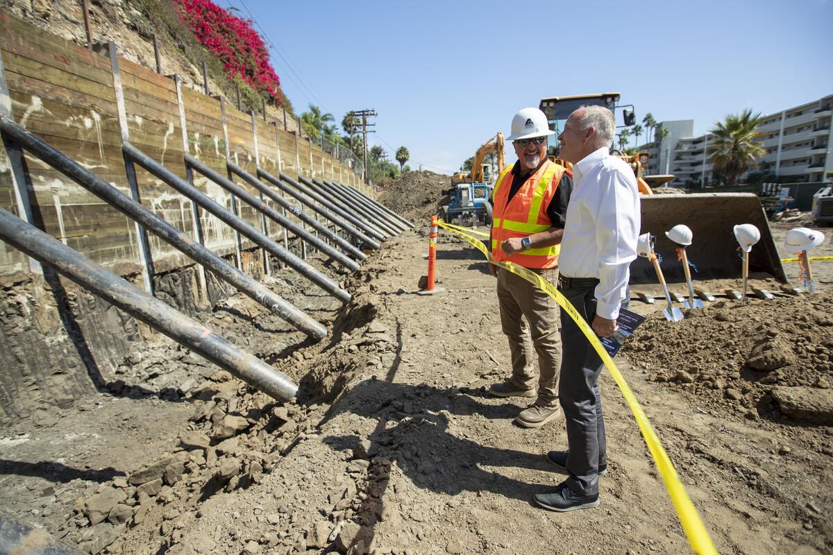 Don Fansler, left, of the East Los Angeles Community Union talks with Larry Frapwell, the architect overseeing the project, during a groundbreaking ceremony Monday for Orange Coast College's new Professional Mariner Training Center. The site is across West Coast Highway from the marine program's sailing and rowing base at Newport Harbor.
