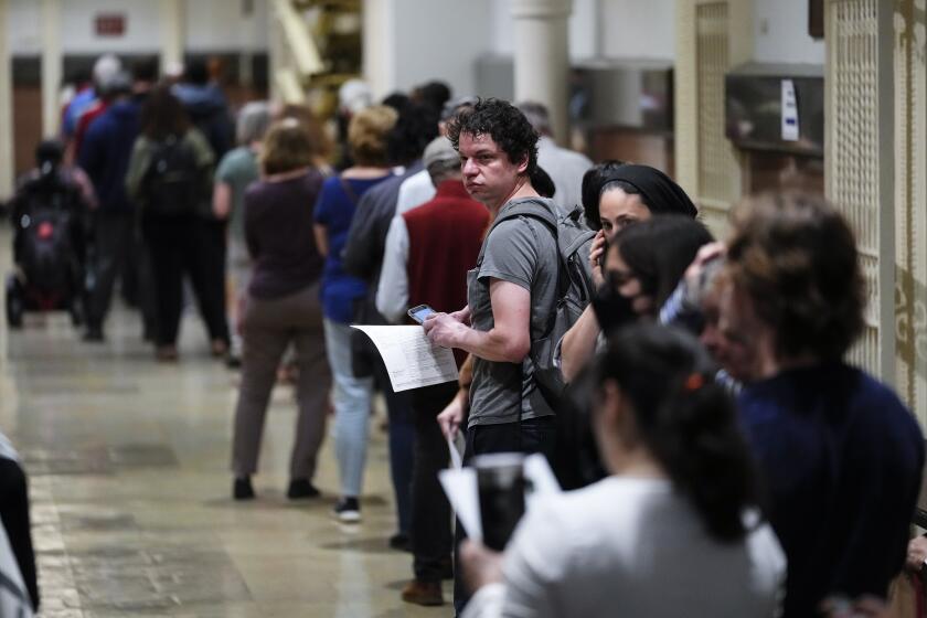 Voters wait in line to make a corrections to their ballots for the midterm elections at City Hall in Philadelphia, Monday, Nov. 7, 2022. (AP Photo/Matt Rourke)