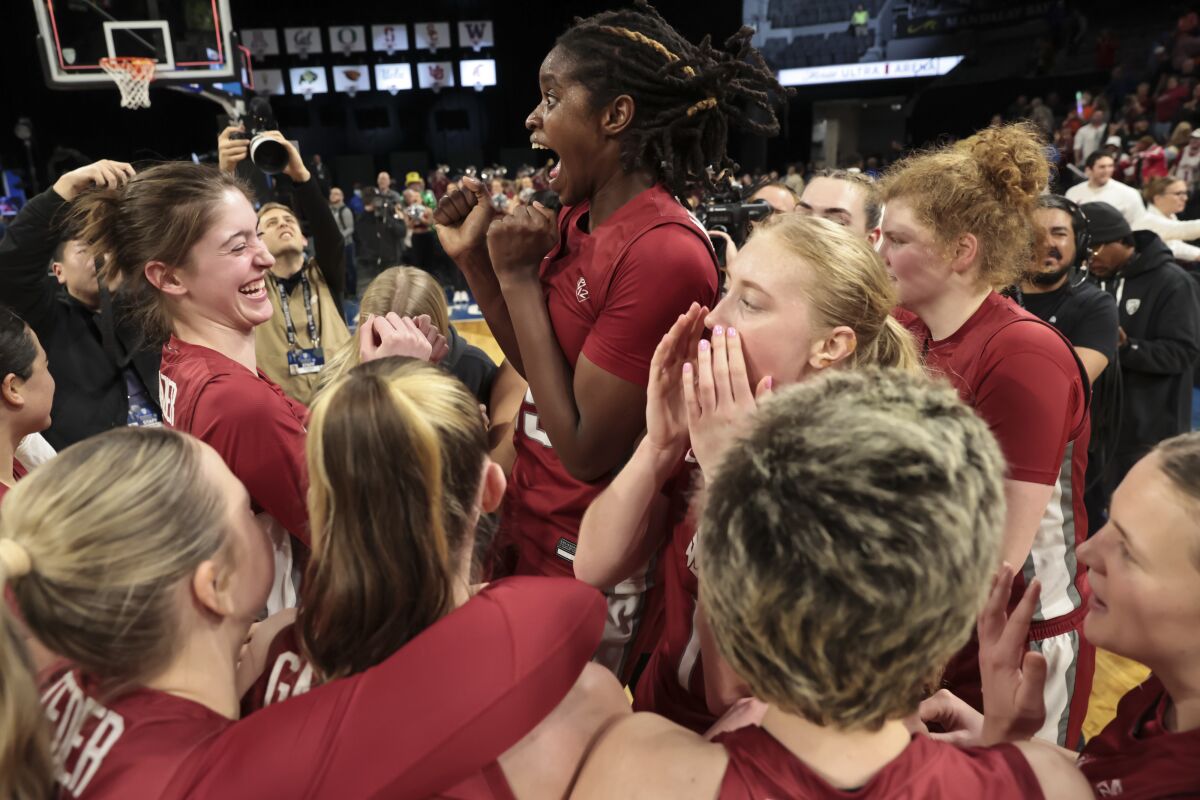 Washington State players celebrate after defeating Colorado in the Pac-12 women's basketball tournament semifinals Friday.