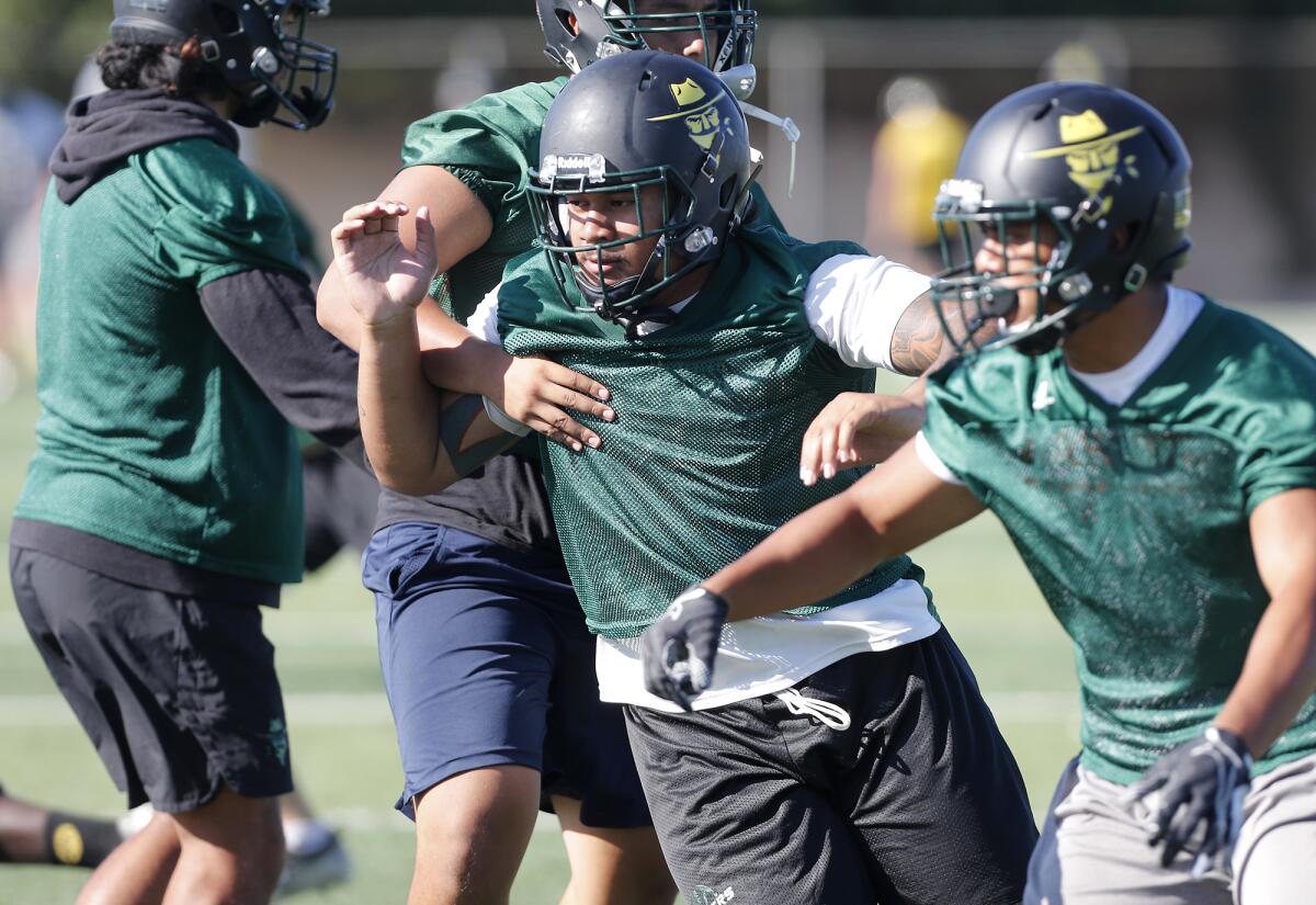 Golden West College defensive tackle V.J. Malo, center, practices on Friday in Huntington Beach.