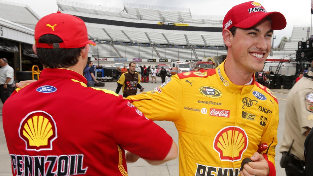 NASCAR driver Joey Logano, right, is congratulated by a crew member Friday after wining the pole the Sprint Cup STP 500.