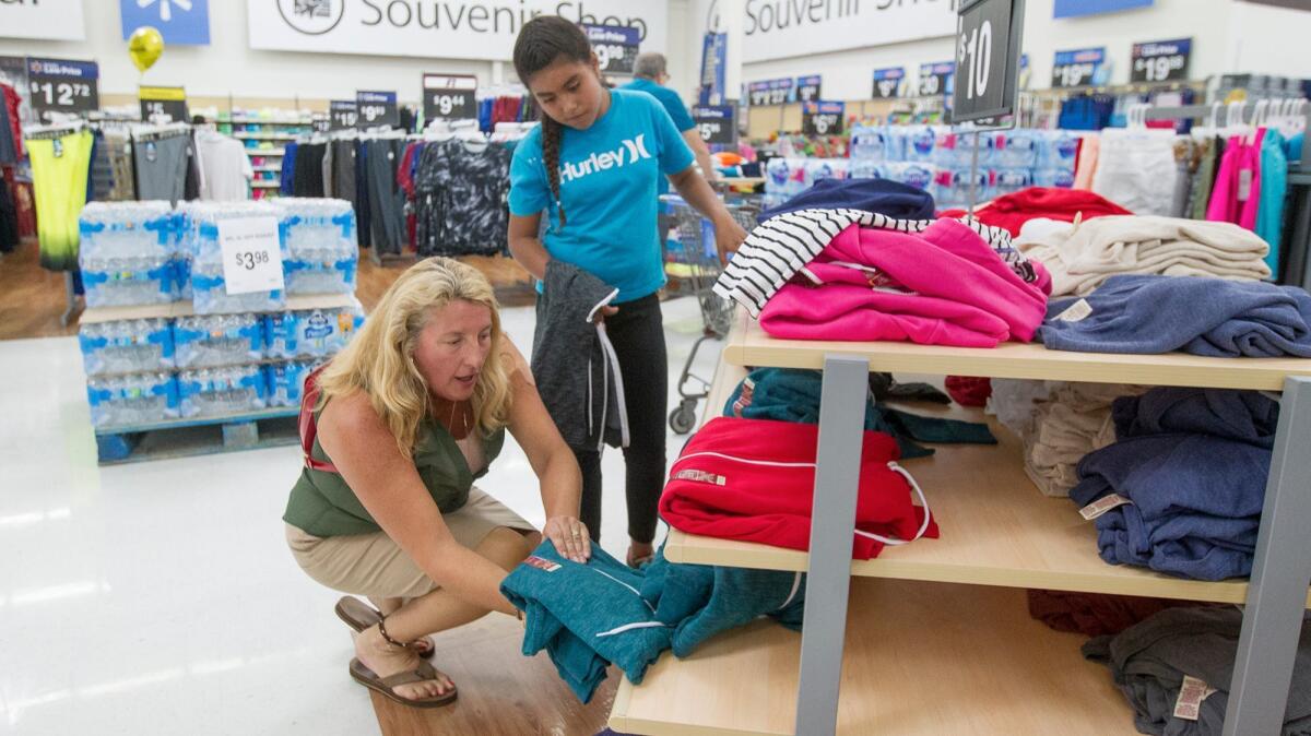 Volunteer Karen Faland helps Marisol Lezama, 10, shop for clothing at Walmart in Huntington Beach on Wednesday during the Boys and Girls Clubs of Huntington Valley shopping spree.