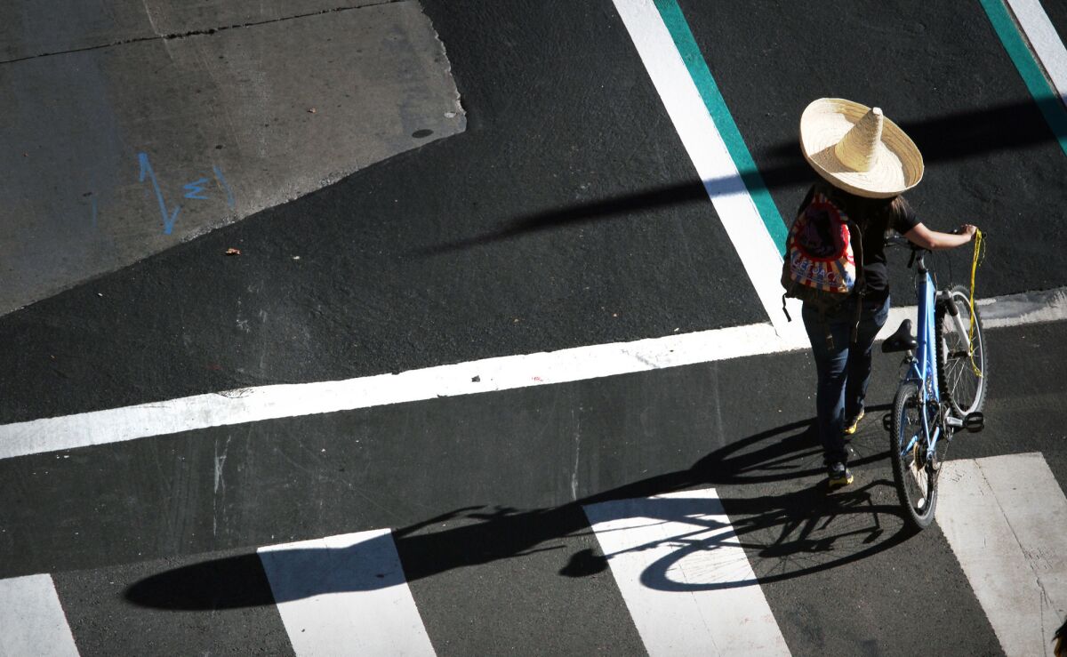 A cyclist with plenty of sun protection walks downtown before joining other CicLAvia riders at 1st and Spring streets as part of the eighth edition of the bike festival.
