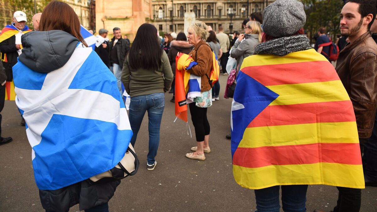 Demonstrators wear the flag of Scotland and the Catalan flag during a demonstration to show solidarity with Catalonia in central Glasgow on Oct. 9.