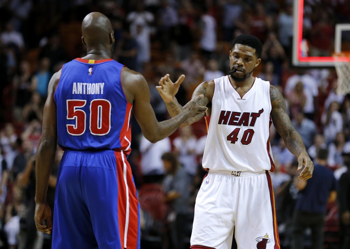 Miami Heat forward Udonis Haslem (40) shakes hands with Detroit Pistons center Joel Anthony (50) after the Heat defeated the Pistons 107-89 in an NBA basketball game, Tuesday, April 5, 2016, in Miami. Anthony is a former Heat player. (AP Photo/Joe Skipper)