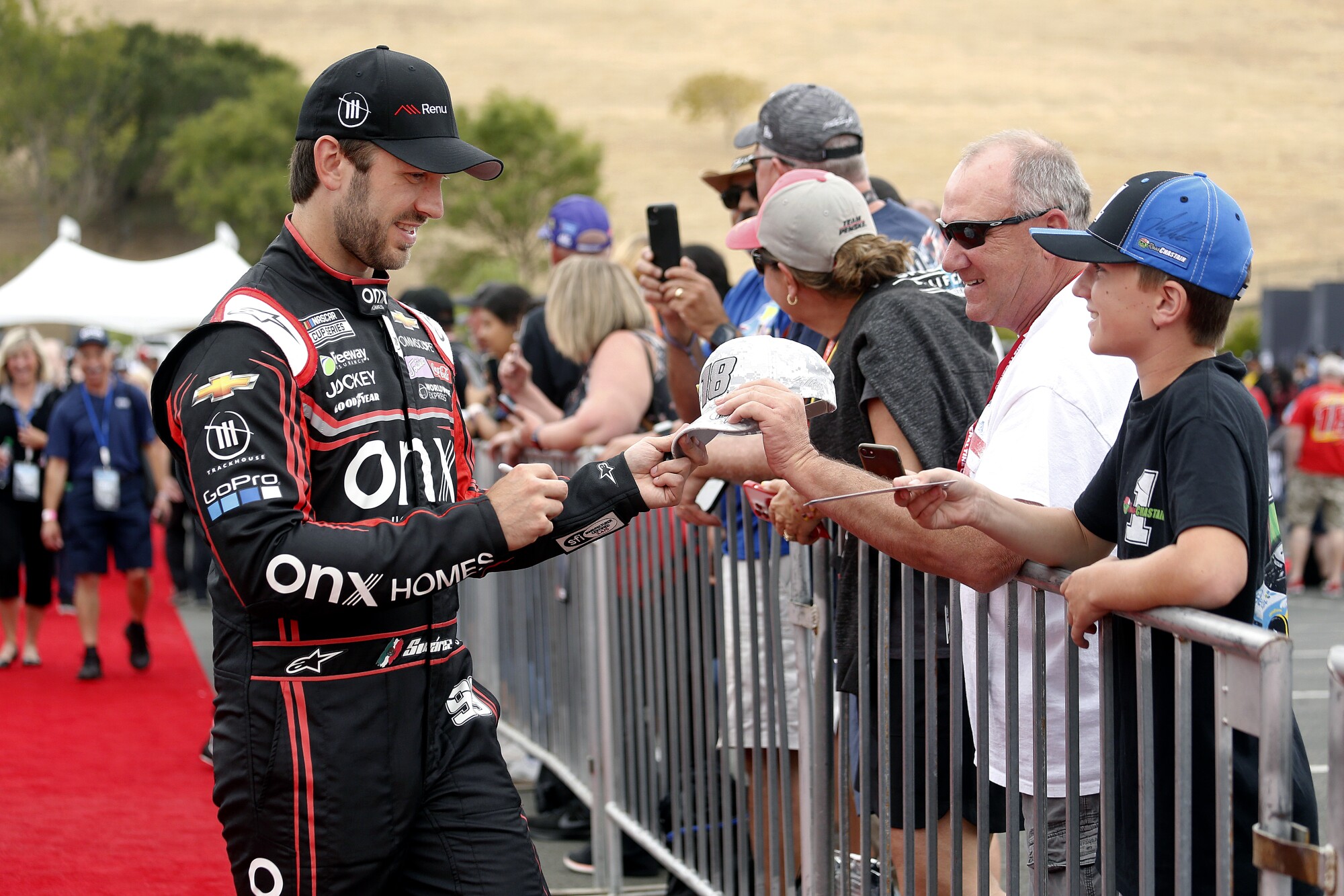 NASCAR driver Daniel Suárez signs autographs for fans at Sonoma Raceway.