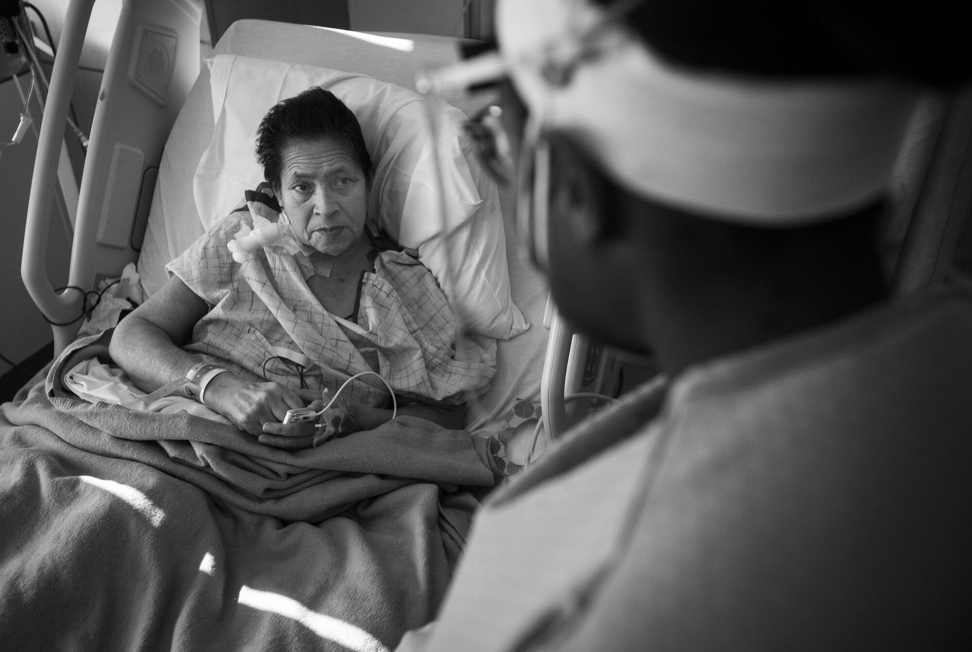 Patient Maria Cuellar, left, speaks to Dr. Maita Kuvhenguhwa, an infectious-disease specialist.