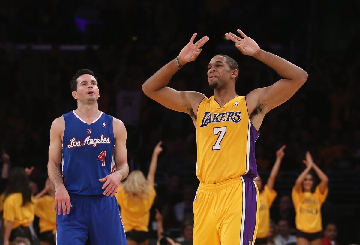Clippers guard J.J. Redick, left, looks on as Lakers guard Xavier Henry celebrates during the fourth quarter of the Clippers season-opening loss Tuesday. Redick says the Clippers failed to execute on both sides of the ball against the Lakers.