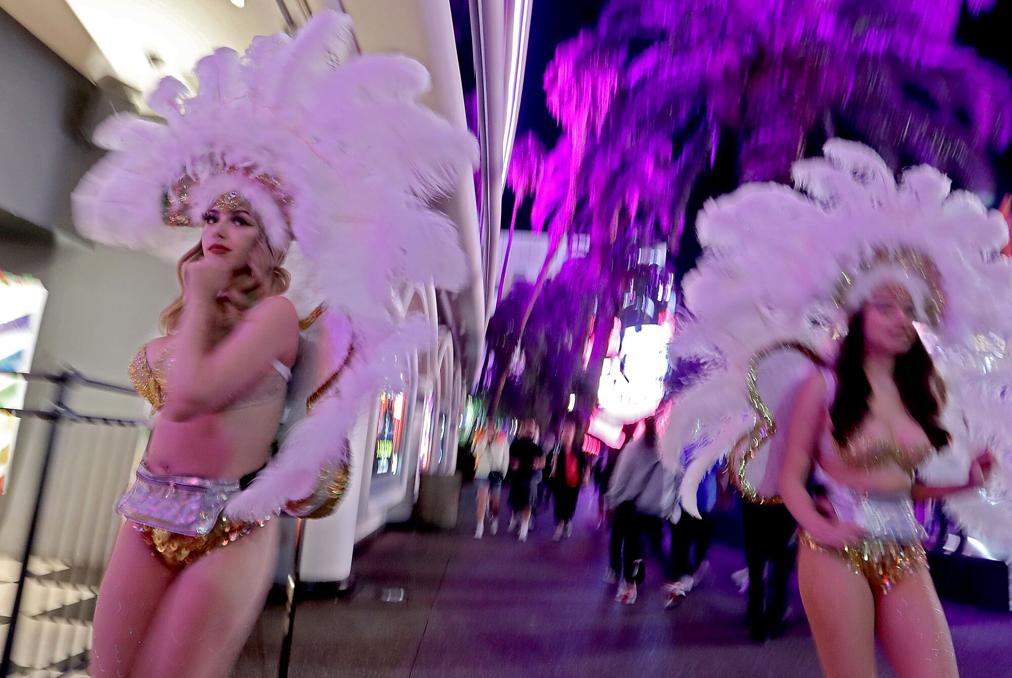 Women in showgirl costumes walk down the Las Vegas Strip, one of the biggest entertainment centers in the world.