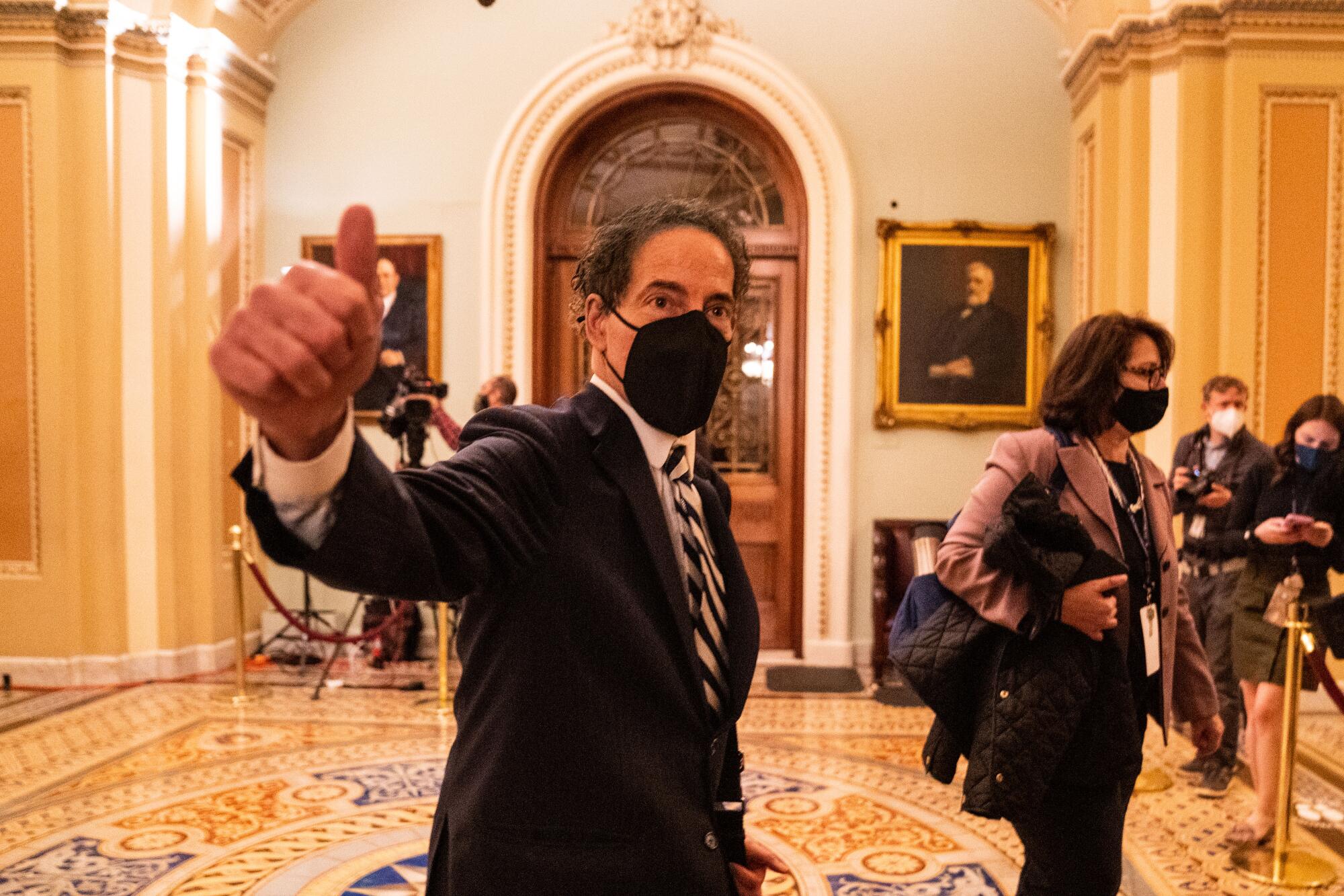 A congressman in a mask gives a thumbs-up