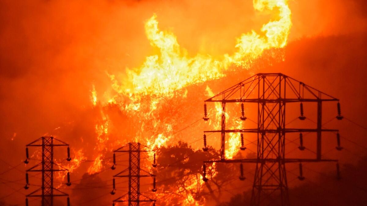 Flames burn near power lines in Montecito, Calif., in December. (Mike Eliason / Associated Press)