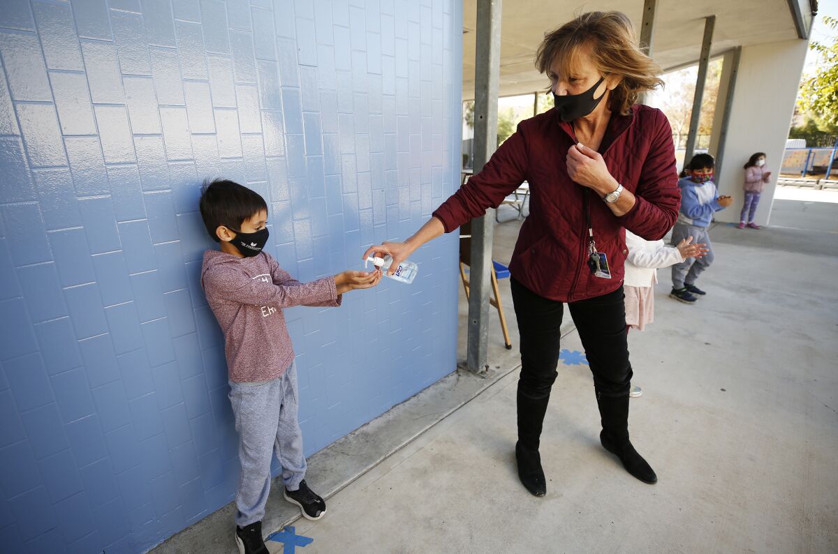 Calabasas kindergarten teacher Jennifer Klein administers hand sanitizer to students on the playground.