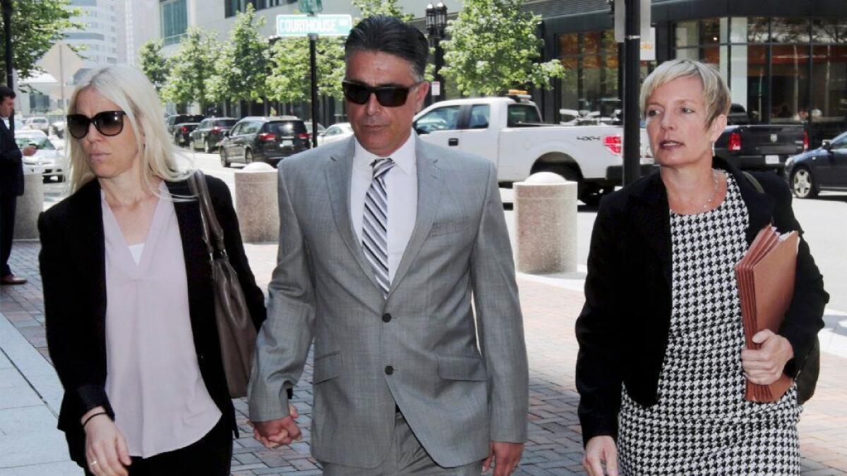 Former USC women's soccer coach Ali Khosroshahin, center, arrives at federal court Thursday to plead guilty to charges in a nationwide college admissions bribery scandal.
