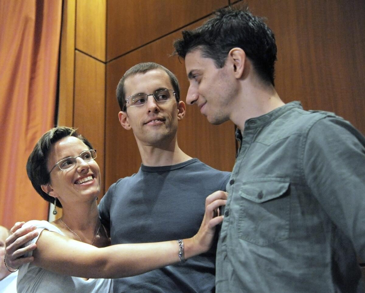 Released U.S. hikers Shane Bauer, center, and Josh Fattal, right, are embraced by fellow hiker Sarah Shourd after a press conference in New York. Bauer and Fattal were jailed in Iran and finally freed on Sept. 21, 2011 after almost 26 months. Shourd was jailed in an Iranian prison for 410 days.