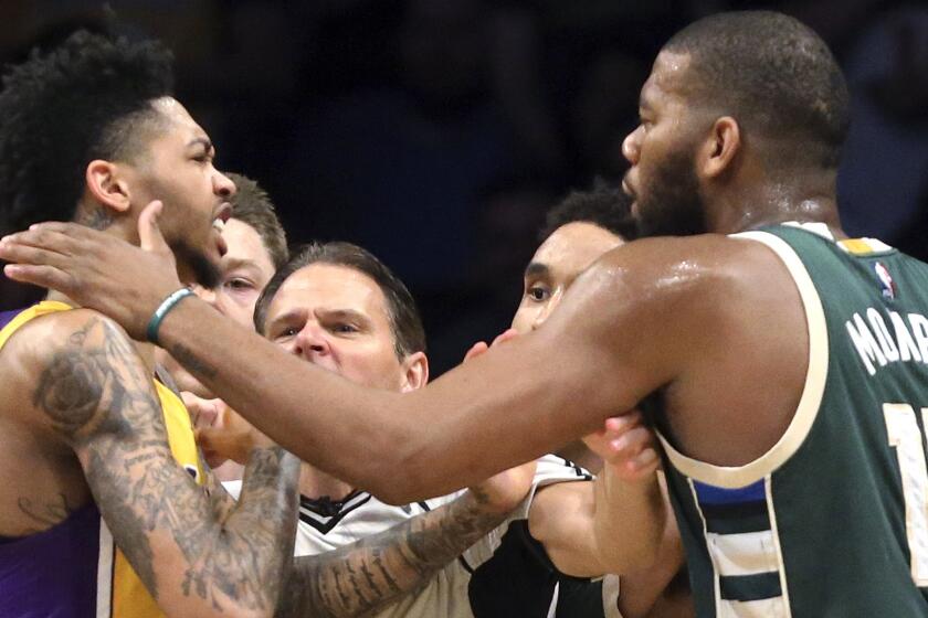 Lakers forward Brandon Ingram, left, and Bucks center Greg Monroe are separated by a referee during an altercation during the third quarter of their game Friday night.