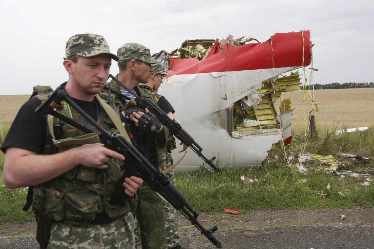Armed pro-Russia militants pass next to the wreckage of a Malaysia Airlines Boeing 777 that crashed last week in eastern Ukraine.