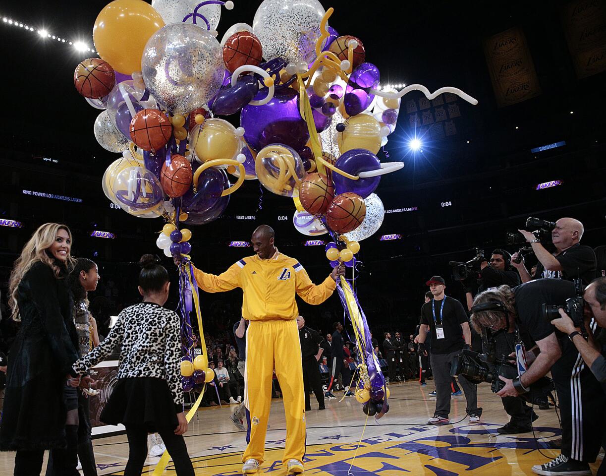 Kobe Bryant receives a passel of balloons with his wife Vanessa and daughters Gianna and Natalia in attendance for a pregame ceremony to honor the Lakers guard for moving past Michael Jordan into No. 3 on the NBA's all-time scoring list.