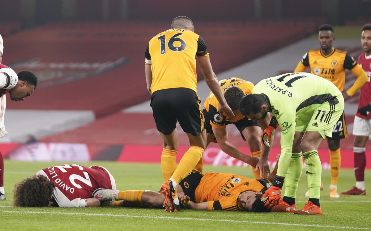 Jugadores atienden a David Luiz del Chelsea y Raúl Jiménez del Wolverhampton tras una colisión 