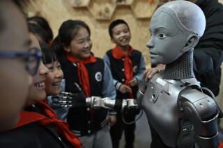 Students interact with a humanoid robot in China.