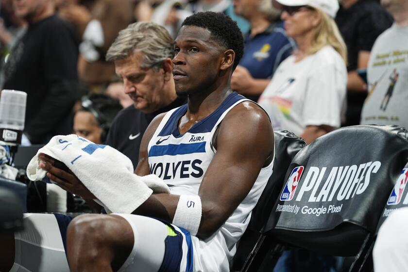 Minnesota Timberwolves guard Anthony Edwards, front, and coach Chris Finch sit on the bench during a timeout late in the second half of Game 5 of the team's NBA basketball second-round playoff series against the Denver Nuggets on Tuesday, May 14, 2024, in Denver (AP Photo/David Zalubowski)