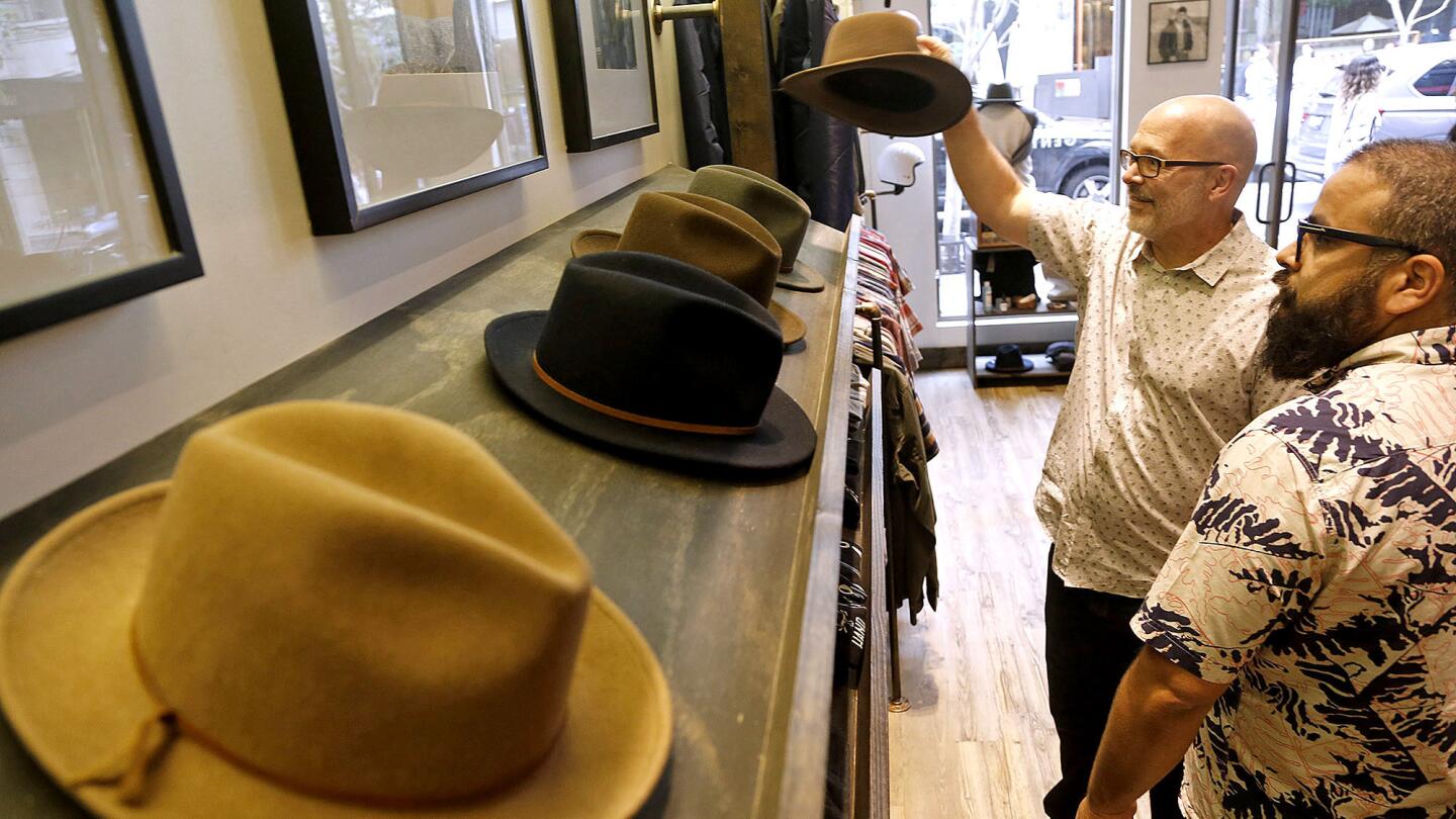 Richard Ruskell, left, and Alex Castro peruse fedora hats for sale at Tankfarm.