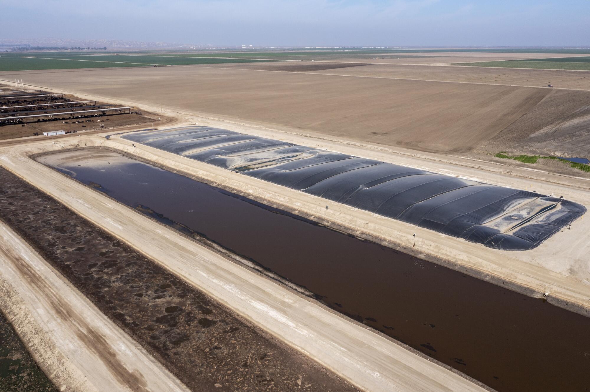 A covered lagoon methane digester, right, at a dairy in Bakersfield.