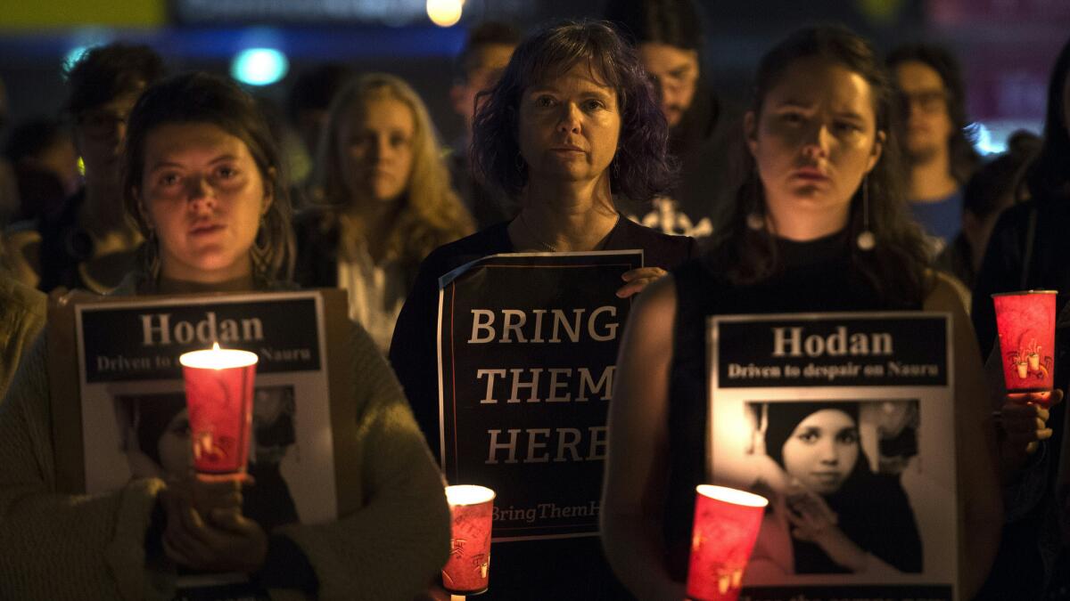 People in Sydney hold a vigil honoring two refugees who set themselves on fire in the remote island of Nauru, where Australia is indefinitely detaining hundreds of asylum seekers.