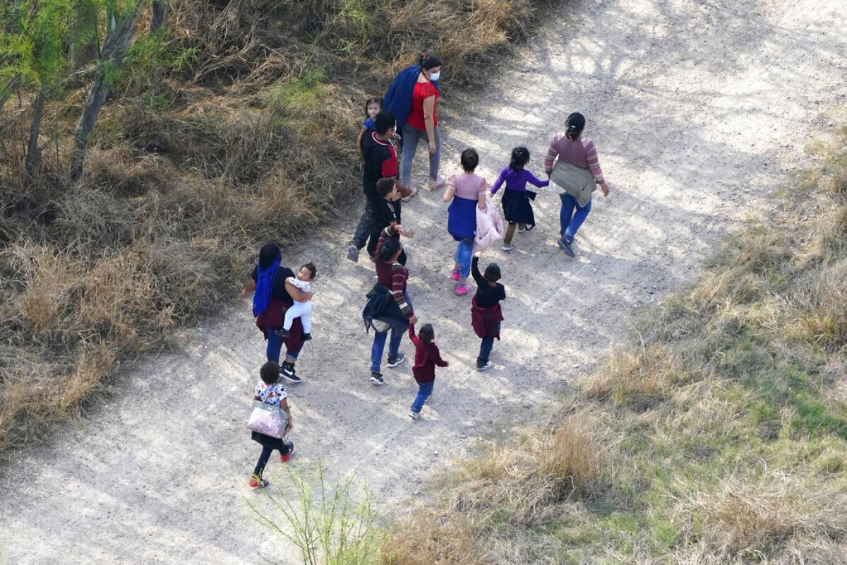 Familias de migrantes fotografiadas en un camino de tierra