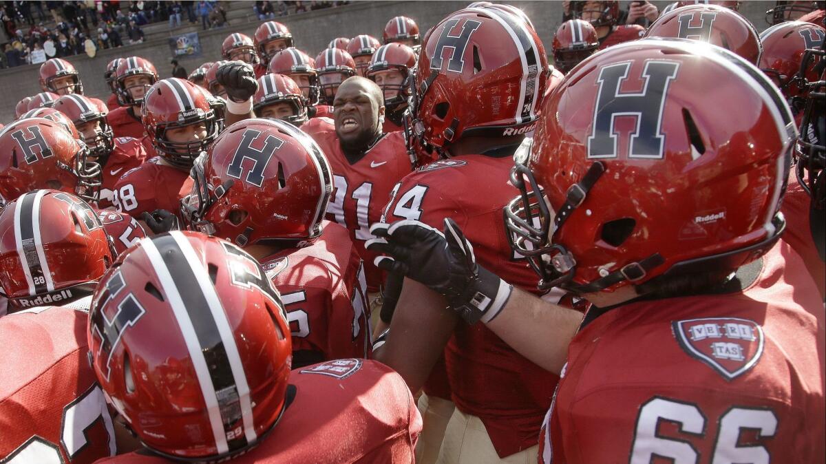 Members of the Harvard football team prepare to take the field in an NCAA game in Cambridge, Mass. on Nov. 22, 2014.