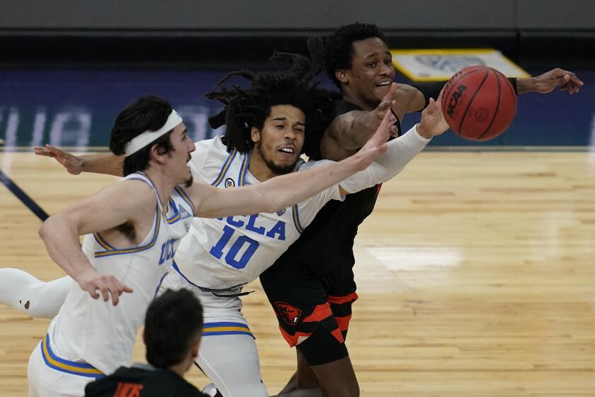 UCLA's Jaime Jaquez Jr., left, Tyger Campbell, center, and Oregon State's Gianni Hunt battle for the ball during the second half of an NCAA college basketball game in the quarterfinal round of the Pac-12 men's tournament Thursday, March 11, 2021, in Las Vegas. (AP Photo/John Locher)