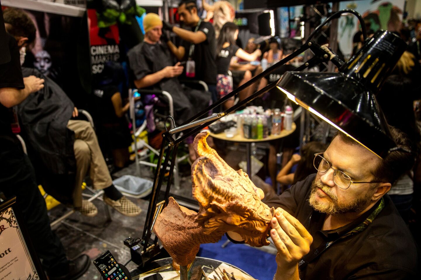 Lee Joyner demonstrates a sculpting technique at the Cinema Makeup School booth in Hall H during the first day of the 2018 San Diego Comic-Con International.