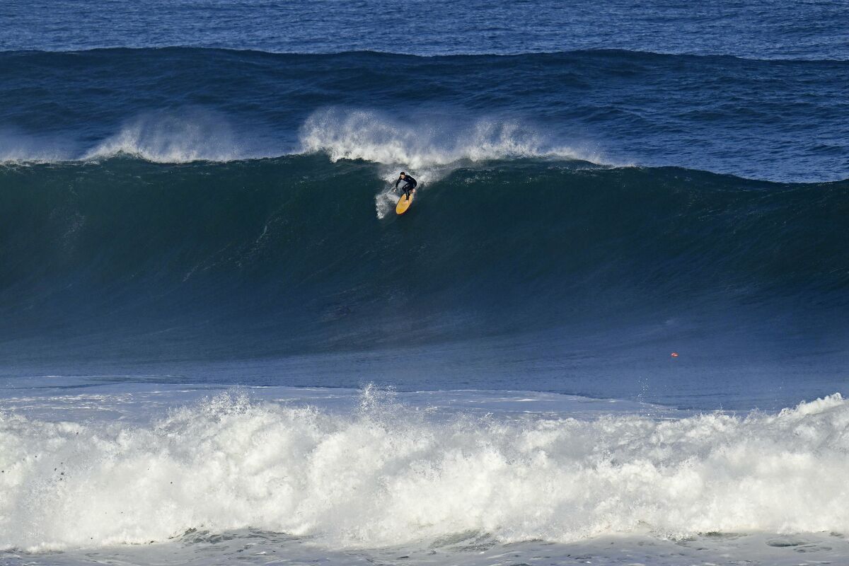 A surfer takes off on an early morning wave at La Jolla Cove on Friday.