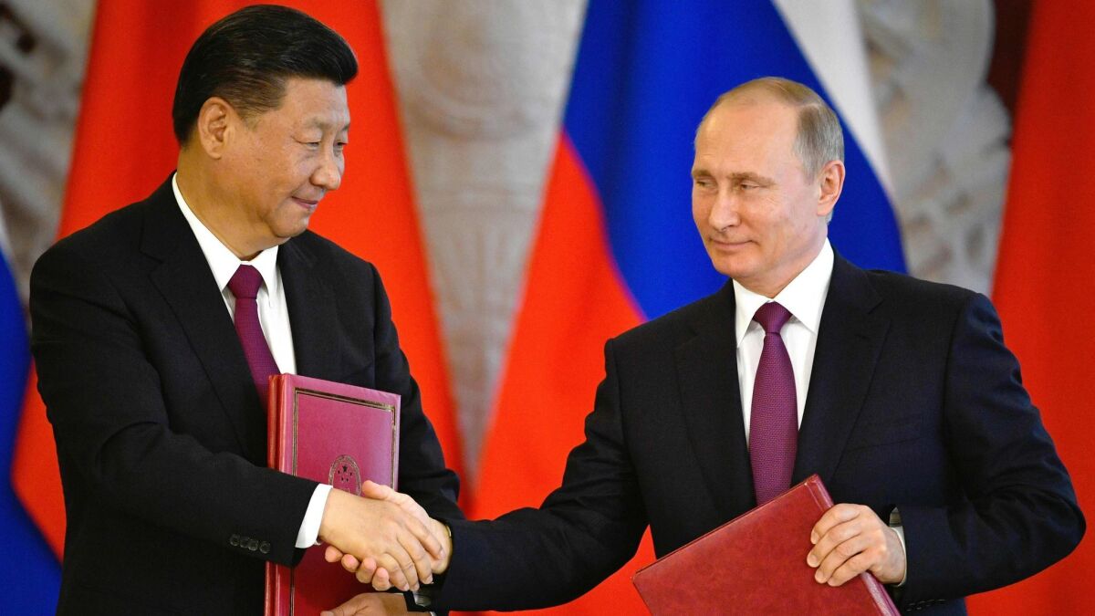 Russian President Vladimir Putin, right, and his Chinese counterpart, Xi Jinping, shake hands during a signing ceremony in the Kremlin in Moscow on July 4, 2017.
