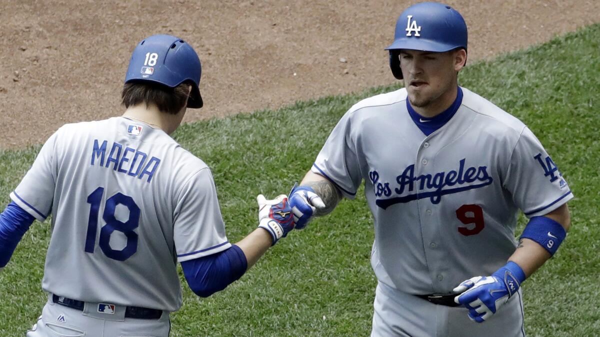 Dodgers catcher Yasmani Grandal is congratulated by pitcher Kenta Maeda after hitting a solo home run in the fourth inning Thursday.