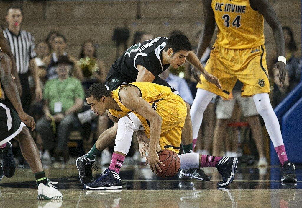 UC Irvine's Alex Young scrambles after a loose ball against Hawaii's Christian Standhardinger during a game on Saturday.