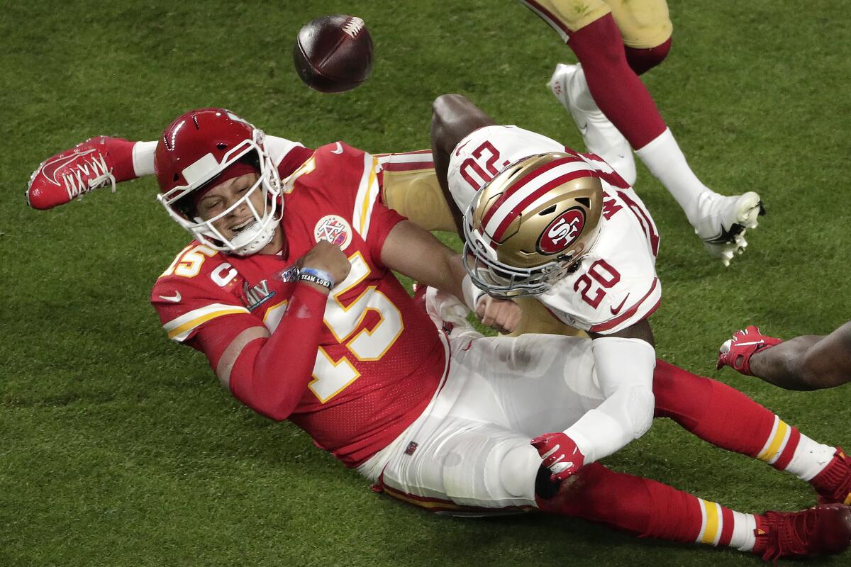 The 49ers' Jimmie Ward jars the ball loose from the hands of Patrick Mahomes, who had run for a first down until he fumbled the ball backward.