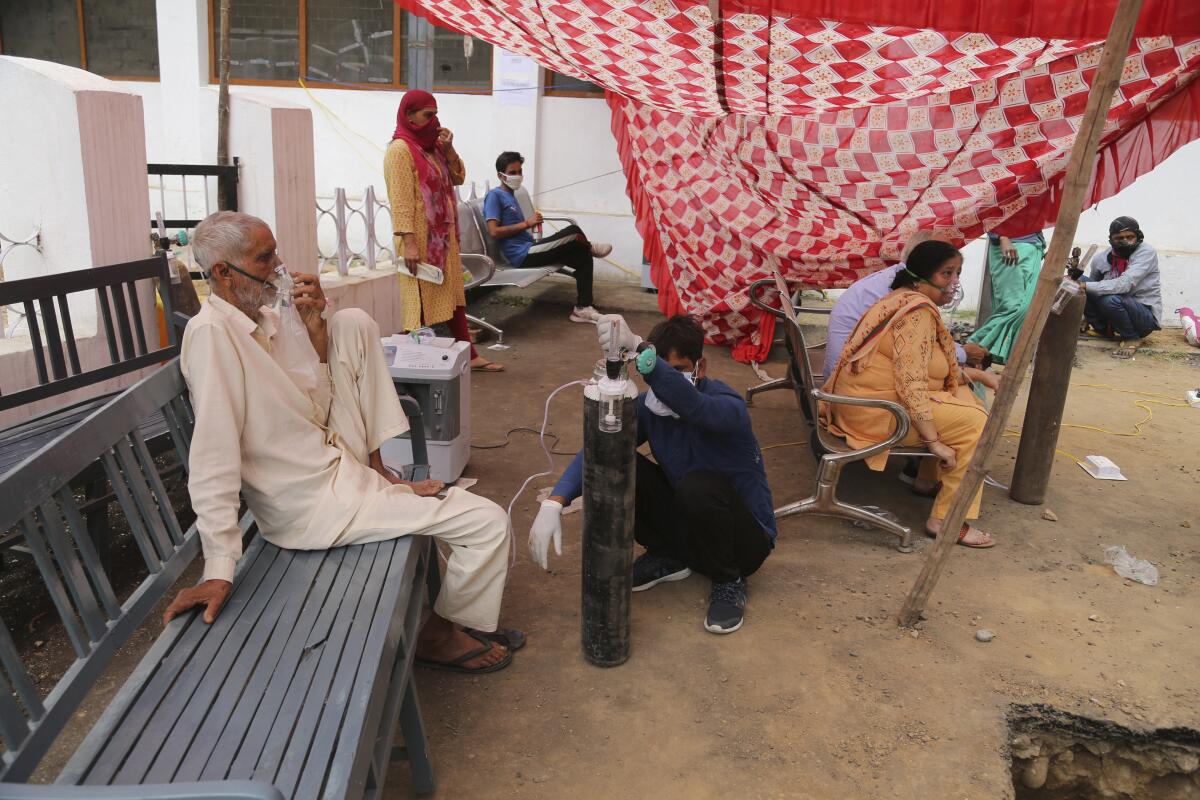 A COVID-19 patient receives oxygen outside a hospital