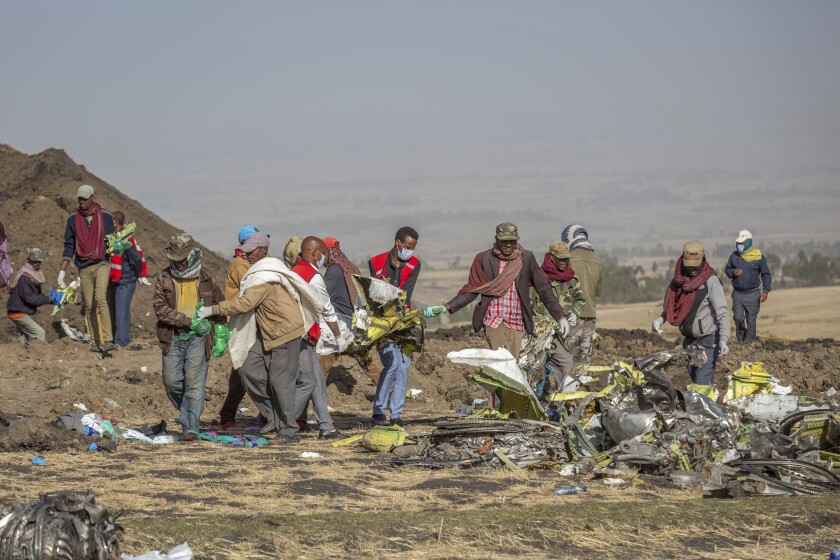 FILE - Rescuers work at the scene of an Ethiopian Airlines flight crash near Bishoftu, or Debre Zeit, south of Addis Ababa, Ethiopia, Monday, March 11, 2019. Relatives of passengers who died in crashes of Boeing 737 Max jets are pressing Attorney General Merrick Garland to help them re-open a settlement that shielded Boeing from criminal prosecution for misleading federal safety regulators about the plane. Several family members and their lawyers held a video meeting Wednesday, Jan. 26, 2022, with Garland. (AP Photo/Mulugeta Ayene, File)