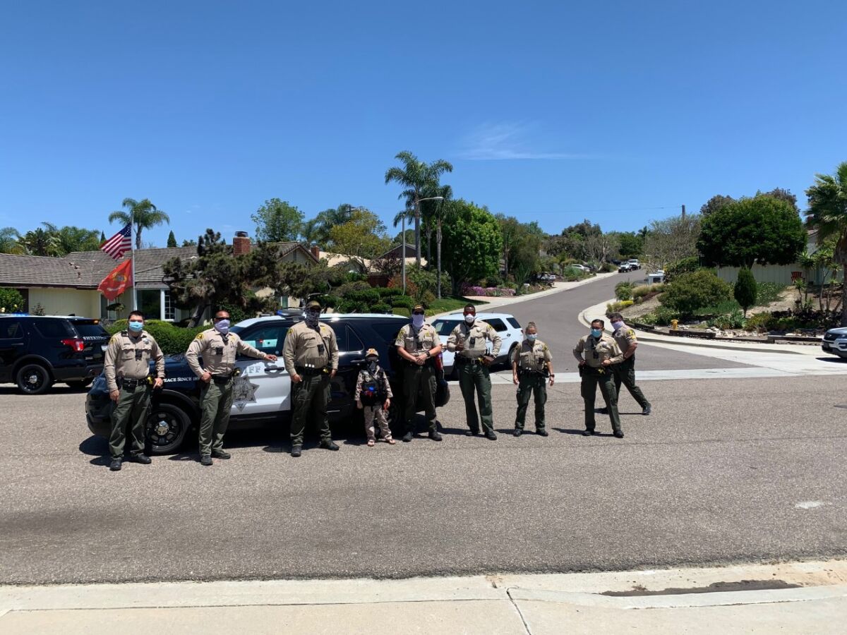 Drew Carlin (center) with sheriff’s deputies at the North Coastal Station on El Camino Real.