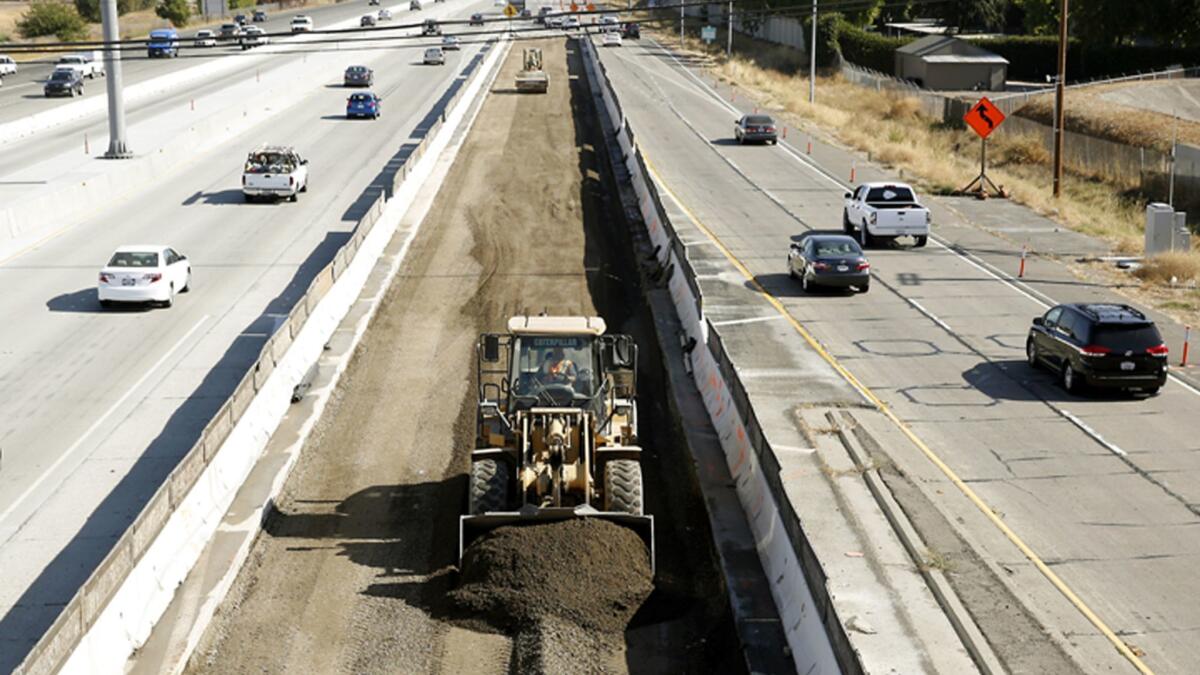 Vehicles pass a highway construction site on Interstate 80 in Sacramento in 2015. Voters will consider five state propositions on the primary ballot, including Proposition 69, which would require gas tax money be spent on transportation.